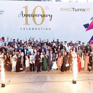 Group photo of HIC Global Solutions team celebrating their 10th anniversary with fireworks and smiles at the company event.